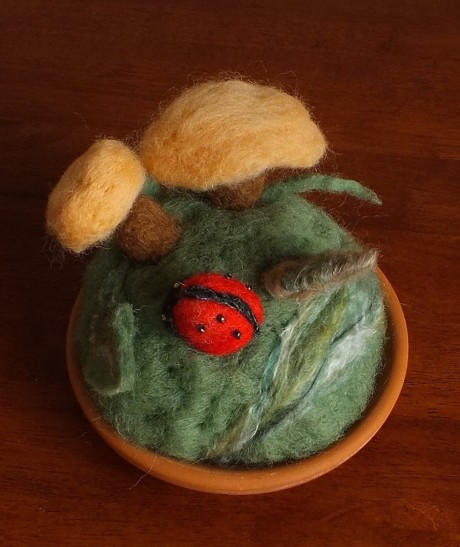 Terracotta dish with felted wool mushrooms and ladybug